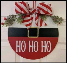 a christmas ornament hanging on a door with red and white striped ribbon around it