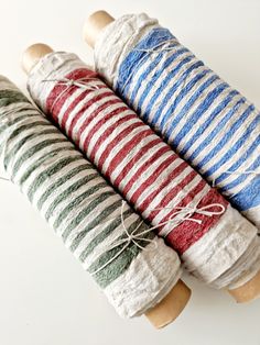 three different colored yarns are on top of each other, and one is wrapped in twine