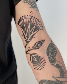 a man's arm with tattoos on it and a bird in the middle of his arm