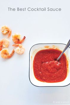 the best cocktail sauce for shrimp is in a small square bowl with a spoon next to it