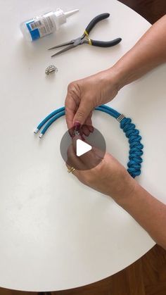 a person is working on some beads with scissors and wire cutters next to them