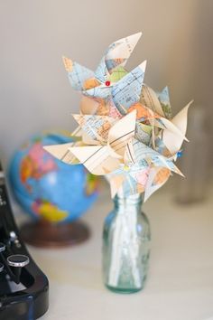 a vase filled with origami flowers on top of a table