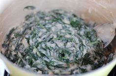 spinach being cooked in a pot on the stove