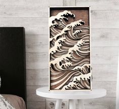 a wooden cutout of waves on a white brick wall