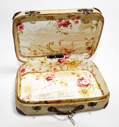 an open suitcase with floral designs on the inside and outside, sitting on a white surface