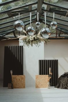 a room filled with lots of mirrors and furniture under a roof covered in metal balls