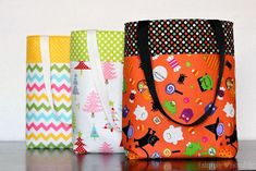 three colorful bags sitting on top of a table next to each other with different designs