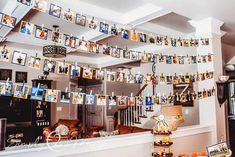 a living room filled with pictures hanging from the ceiling