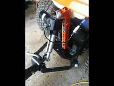 an orange and white boat sitting on top of a metal stand next to a tire