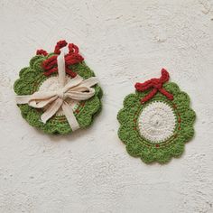 two crocheted ornaments with bows on them