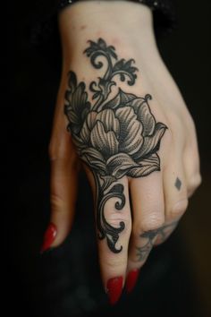 Hand with intricate floral tattoo and red-painted nails. Forearm To Hand Tattoo, Traditional Hand Tattoos For Women, Lace Hand Tattoo, Hand Tattoos Traditional, Goth Finger Tattoos, Goth Hand Tattoos, Men Hair Bun, Traditional Finger Tattoos