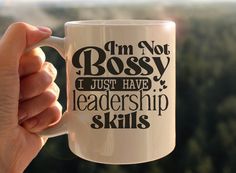 a person holding up a coffee mug that says i'm not bossy, i just have leadership skills