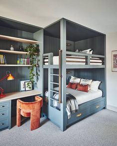 a bedroom with bunk beds and desks in the corner, along with other furniture