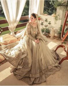 a woman sitting on top of a bed in a dress