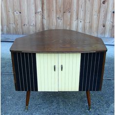 a wooden table with two doors on the front and one door open to reveal a cabinet