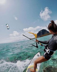 a woman is windsurfing in the ocean while holding on to a rope