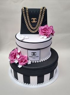 a three tiered cake with flowers and chanel bag on it's top