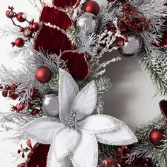 a christmas wreath with silver and red ornaments