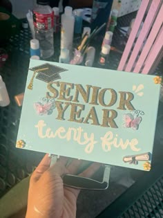 someone holding up a sign that says senior year twenty five