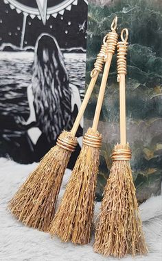 two brooms sitting next to each other on top of snow covered ground with an umbrella in the background