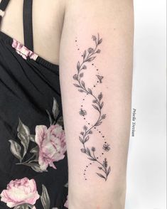 a woman's arm with flowers and stars on the back of her left arm