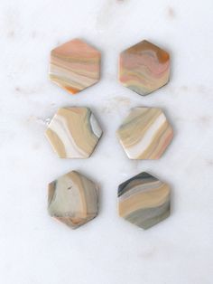 four marble hexagons sitting on top of a white counter