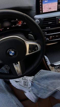 the interior of a bmw car with an entertainment system and steering wheel view from behind