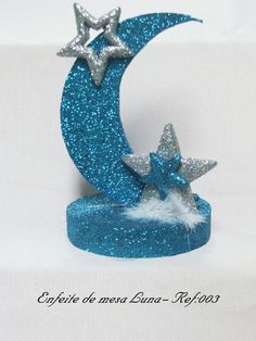 a blue moon with two silver stars on it's side and a white background