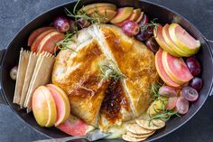 a pan filled with bread, fruit and crackers