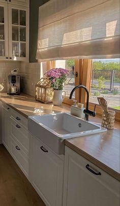 a white kitchen sink sitting under a window