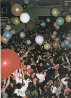 a large group of people with balloons in the air