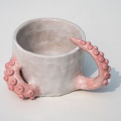 a ceramic cup with an octopus design on the outside and inside, sitting on a white surface