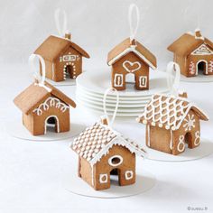 small gingerbread houses with white icing on plates