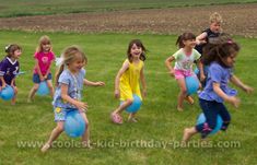 a group of young children playing with blue balloons