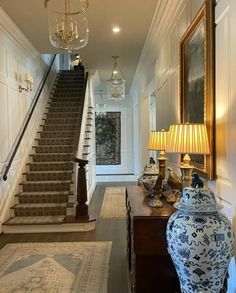 the hallway is decorated with blue and white vases, lamps, and rugs