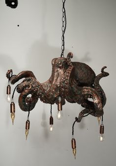 an octopus chandelier hanging from a chain with lights attached to it's sides