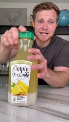 a man holding a bottle of pineapple juice