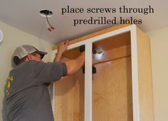 a man is working on the ceiling in his kitchen, with words above him that read place screws through pre - rolled holes