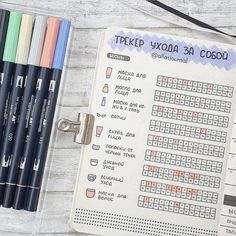 an open notebook with several different colored pencils next to it