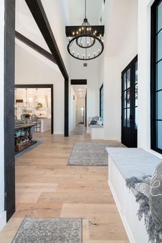 a long hallway with lots of windows and rugs on the floor