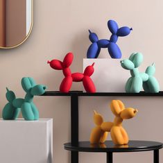 three different colored balloons sitting on top of a black table next to a white box