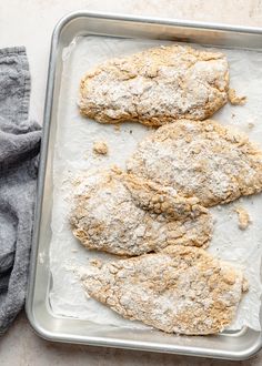 three uncooked fish fillets on a baking pan with floured crusts