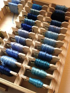 several spools of thread in a wooden box