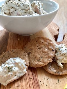 some crackers are next to a bowl of cream cheese