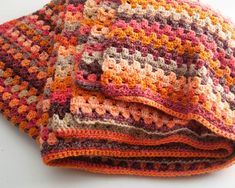 two crocheted blankets folded on top of each other, one is multicolored