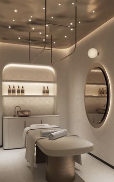 a spa room with mirrors and lights on the wall, two sinks and a large round mirror