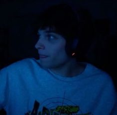 a young man wearing headphones in the dark