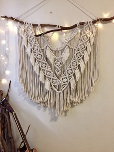 a wall hanging with string lights and tassels on the top, along with other items