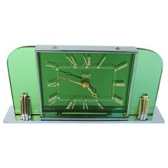 a green clock sitting on top of a metal stand