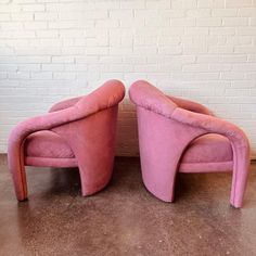 two pink chairs sitting next to each other